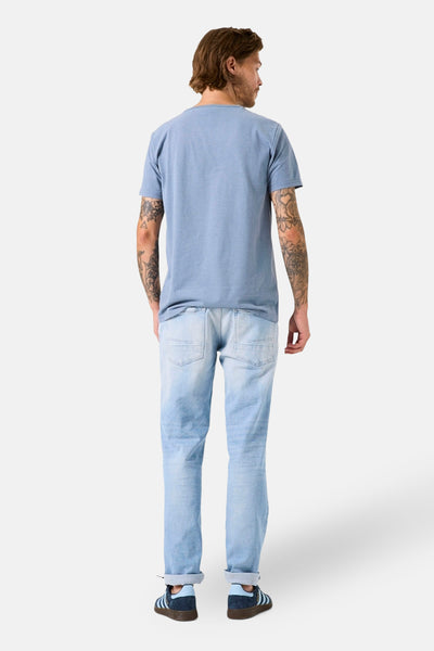 Blauwe korte mouw T-shirt van GARCIA, gedragen met een lichte jeans en sneakers. Achterzijde.