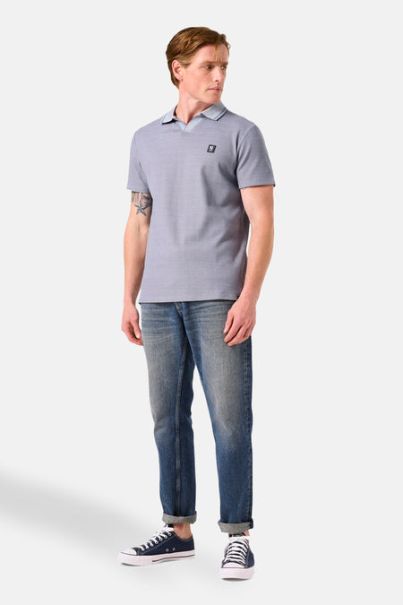 Blauw poloshirt met korte mouwen van GARCIA, gedragen met een spijkerbroek en sportschoenen.
