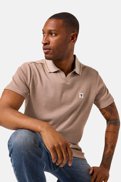 Beige poloshirt met korte mouwen van GARCIA, met contrasterende kraag en ribstructuur, gedragen met een spijkerbroek.