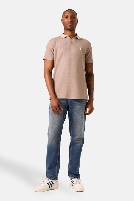 Beige poloshirt met korte mouwen van GARCIA, gedragen met een spijkerbroek en sneakers.