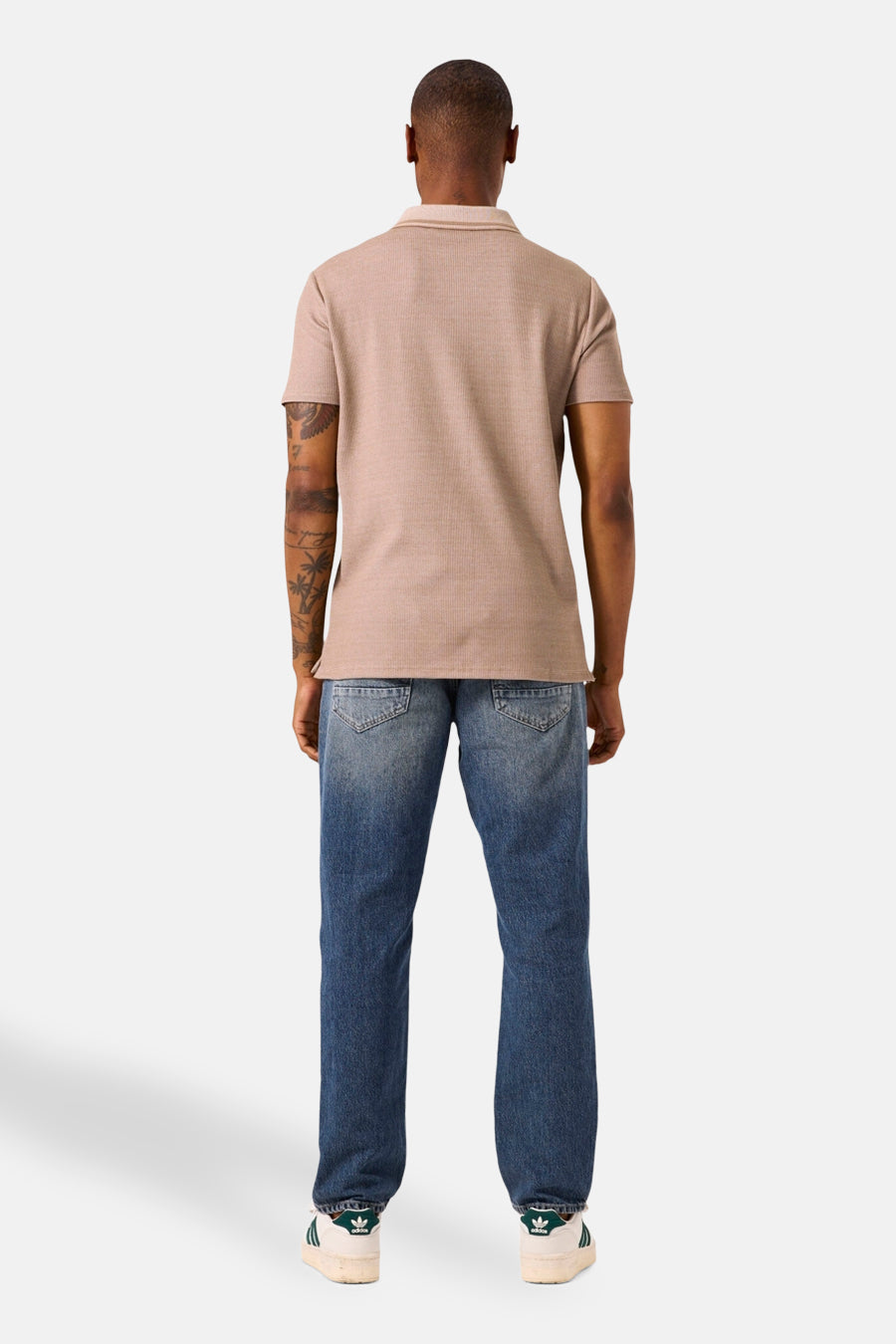Beige poloshirt met korte mouwen van GARCIA, met geribbelde textuur, gedragen met een blauwe jeans en witte sneakers.