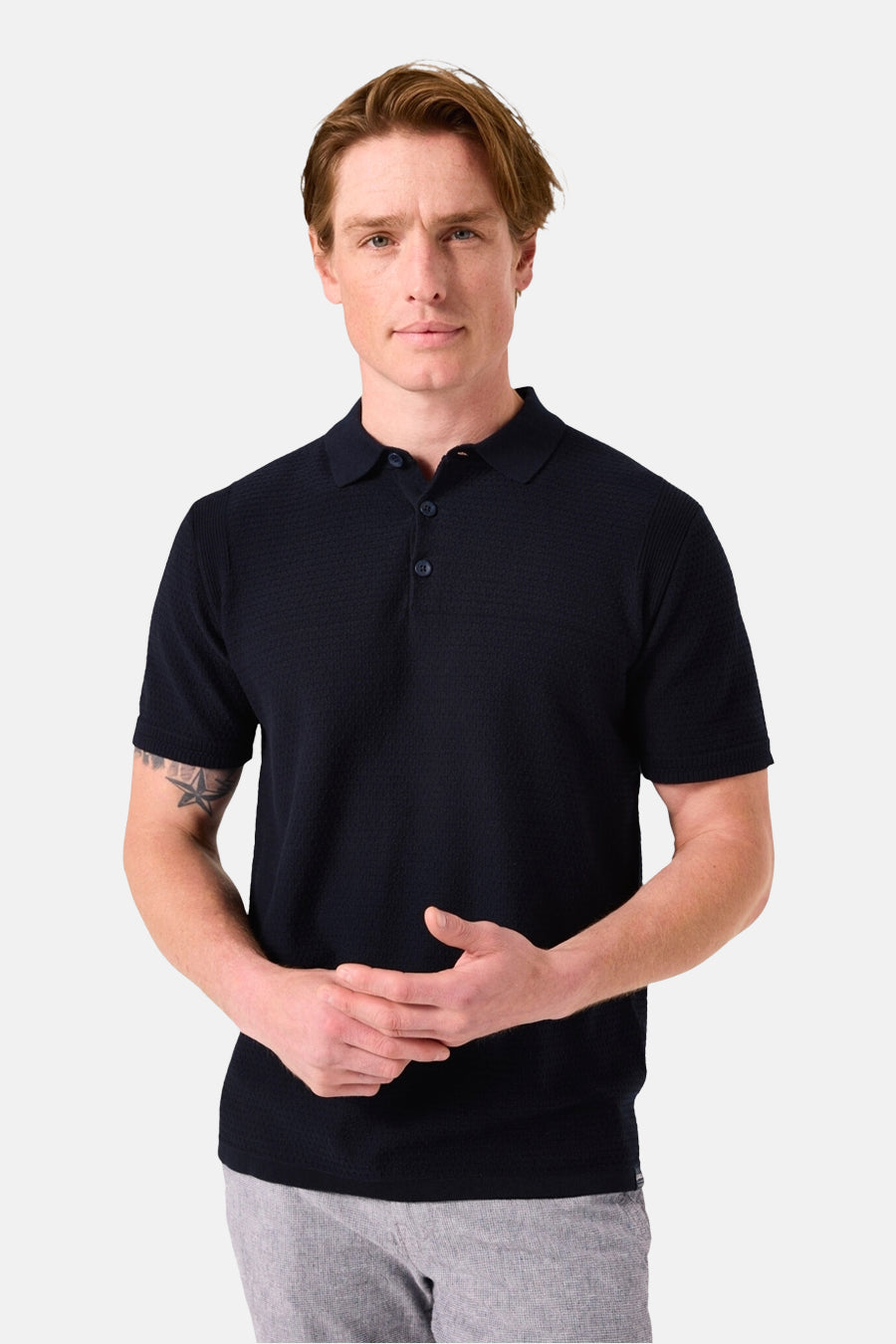 Donkerblauwe polo met korte mouwen van GARCIA met subtiel textuurpatroon gedragen met een grijze broek.