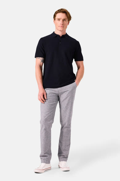 Donkerblauwe polo met korte mouwen van GARCIA, gedragen met een grijze broek en witte schoenen.