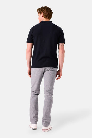 Donkerblauw poloshirt met korte mouwen van GARCIA, gedragen met een grijze broek en witte sneakers.