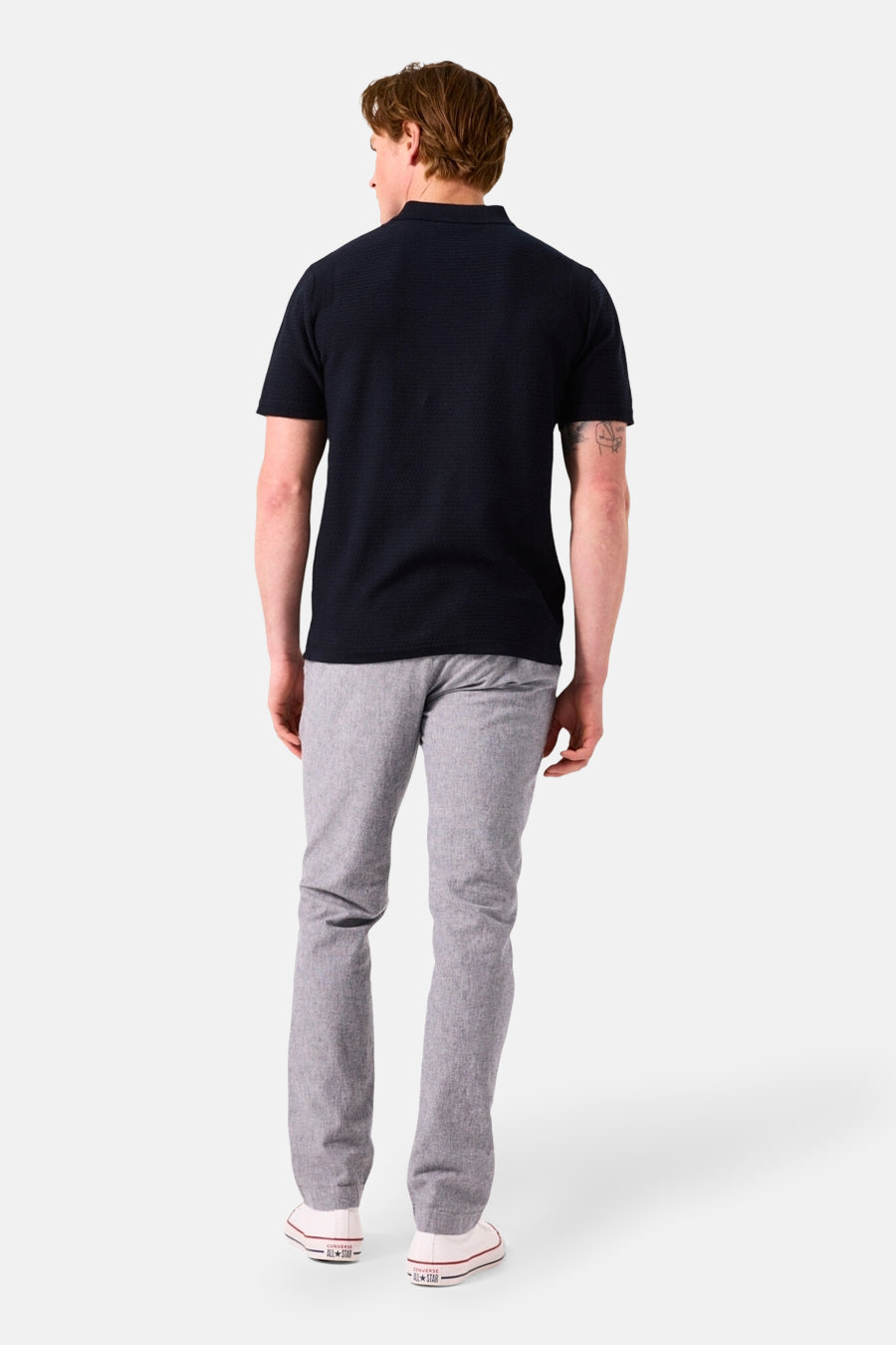 Donkerblauw poloshirt met korte mouwen van GARCIA, gedragen met een grijze broek en witte sneakers.