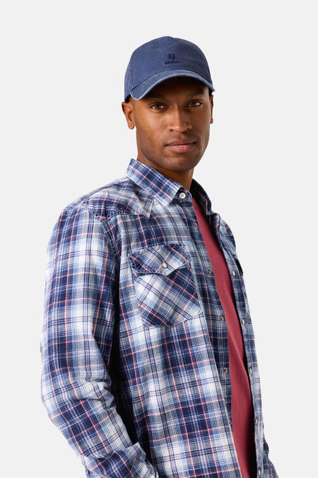 Blauw geruit overhemd met lange mouwen van GARCIA, gedragen over een rood T-shirt en met een lichte spijkerbroek.