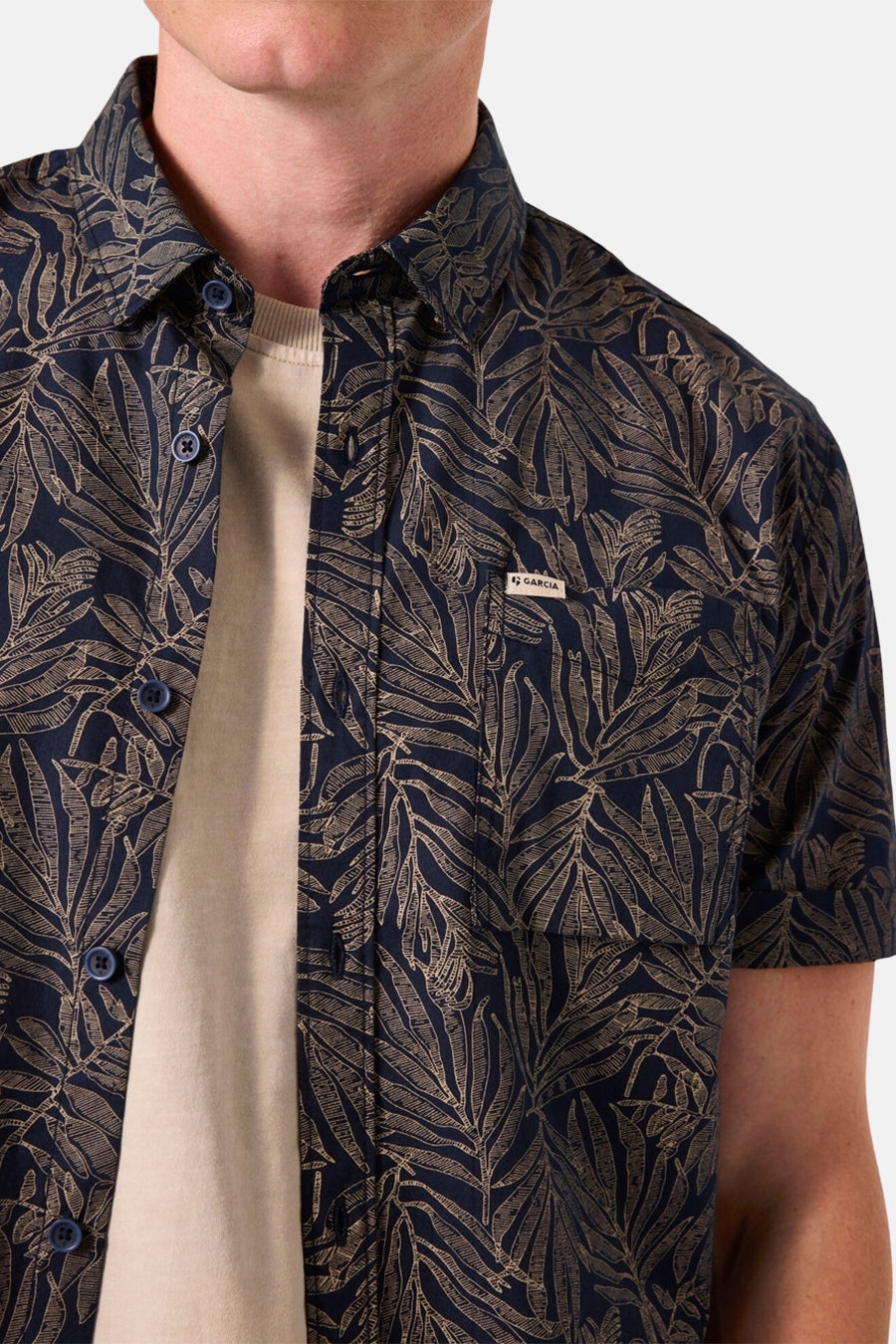 Blauw overhemd met korte mouwen en bladerpatroon van Garcia, gedragen met een beige T-shirt.