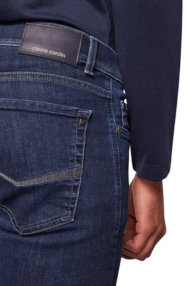 Jean droit bleu de PIERRE CARDIN, avec poche arrière distinctive et étiquette de marque en cuir.
