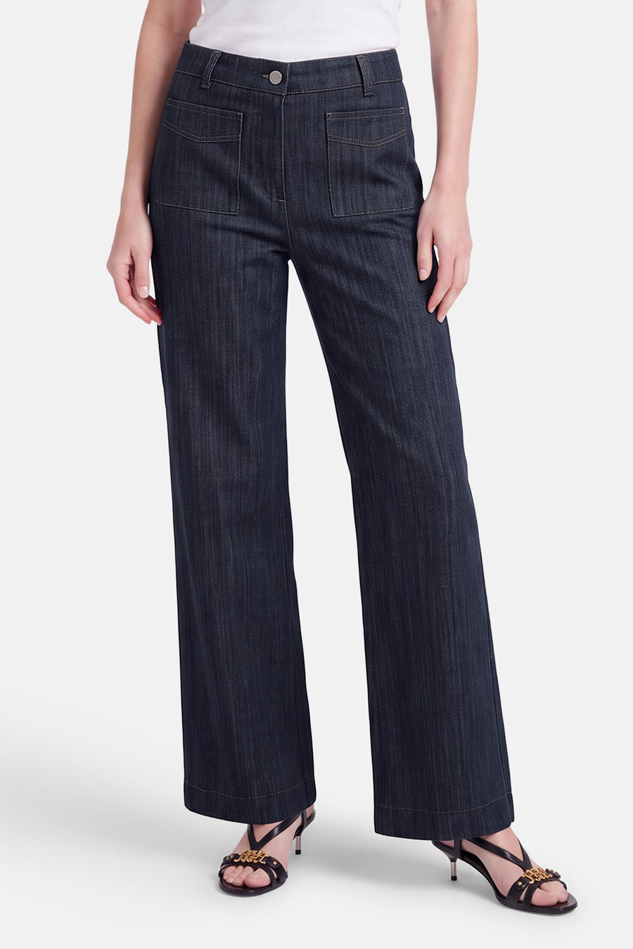 Pantalon de costume en denim bleu foncé par AMELIE ET AMELIE, coupe large, poches avant, vue frontale sur modèle portant sandales à talons.