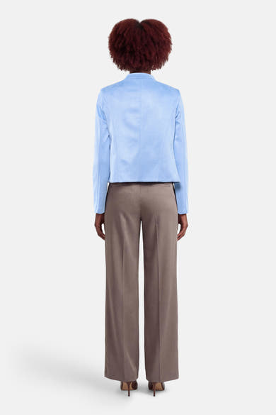 Kort blauw jasje van AMELIE ET AMELIE, met een gladde voering en gedragen met een bruine broek.