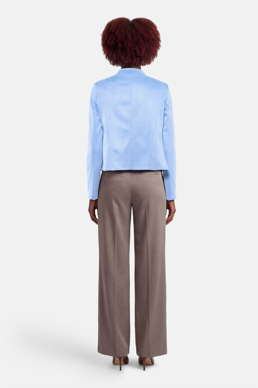 Kort blauw jasje van AMELIE ET AMELIE, met een gladde voering en gedragen met een bruine broek.