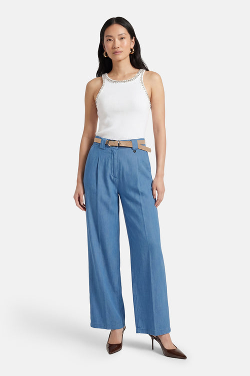 Pantalon de costume bleu clair en denim par AMELIE ET AMELIE, avec ceinture beige et chaussures marron.