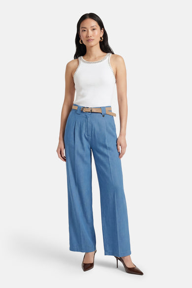 Pantalon de costume bleu clair en denim par AMELIE ET AMELIE, avec ceinture beige et chaussures marron.