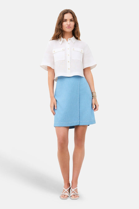 Chemise à manches courtes blanche de CAROLL, texturée, coupe courte, avec deux poches à rabat et boutons dorés.