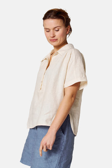 Ecru blouse met korte mouwen van COPINES D'ANVERS, gedragen met een blauwe linnen short.