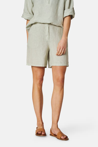Groene linnen bermudashort van COPINES D'ANVERS, gedragen met een bijpassend topje en bruine leren sandalen.