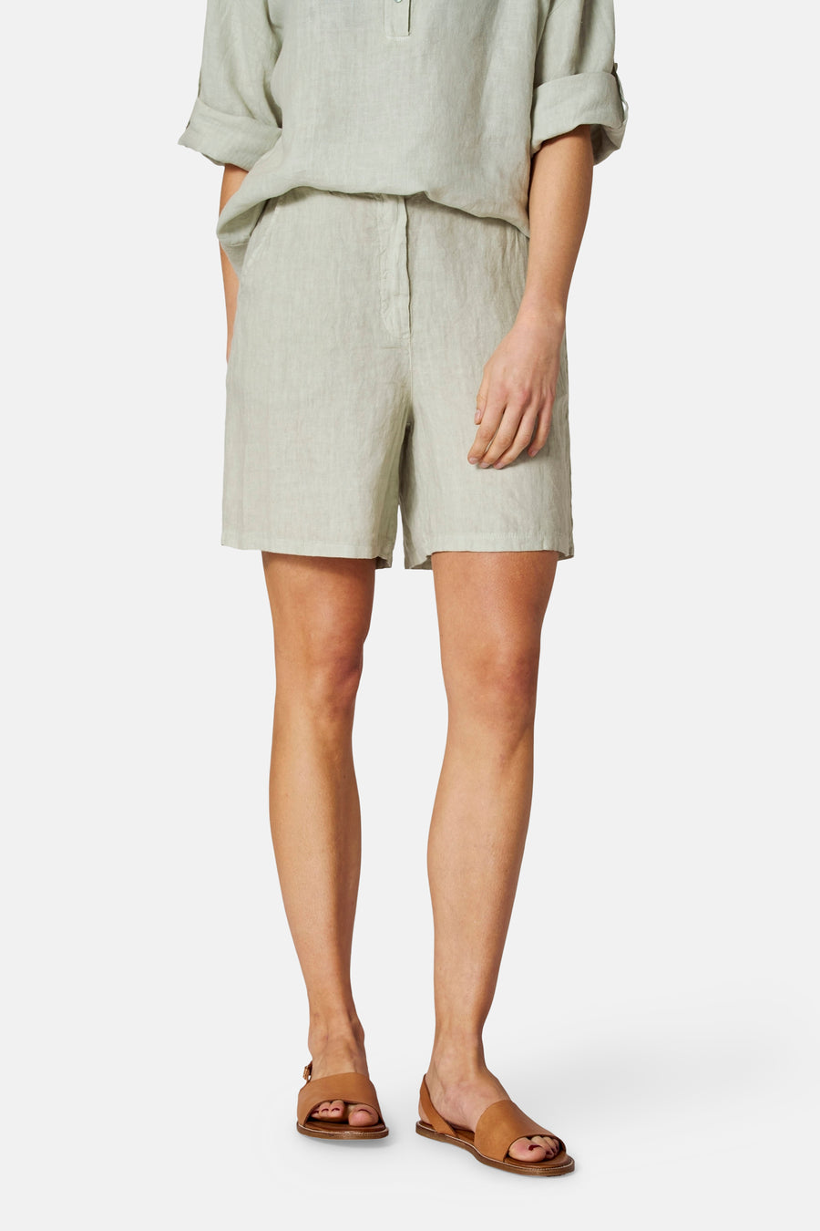 Groene linnen bermudashort van COPINES D'ANVERS, gedragen met een bijpassend topje en bruine leren sandalen.