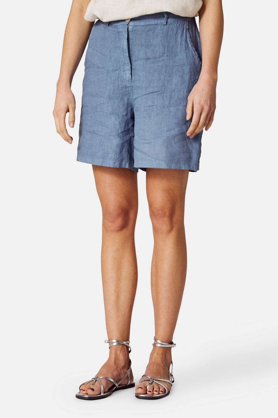 Blauwe linnen bermudashort van COPINES D'ANVERS, gedragen met zilveren sandalen, vooraanzicht.