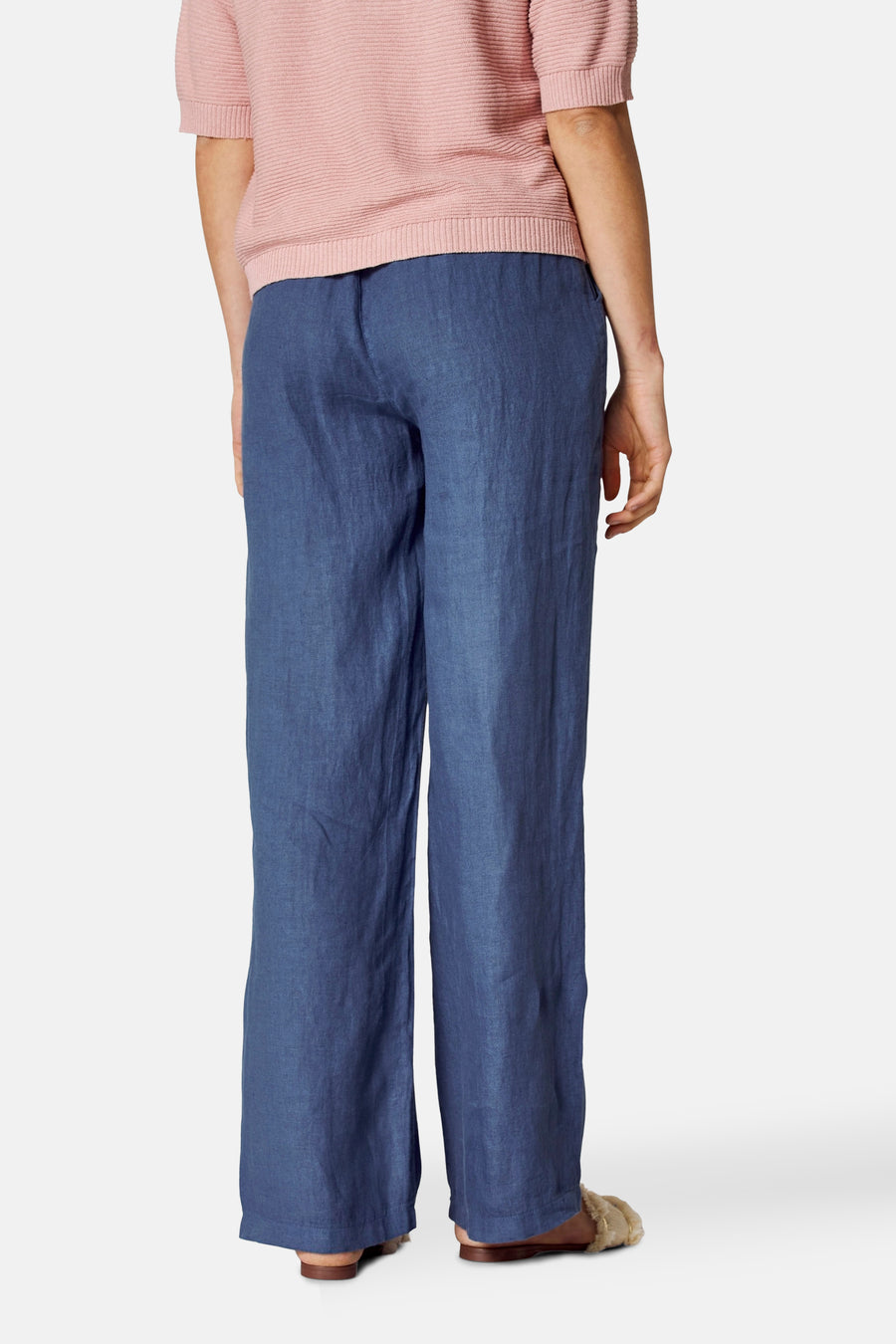 Pantalon coloré bleu de COPINES D'ANVERS, avec un pull rose en tricot côtelé, vue de dos.