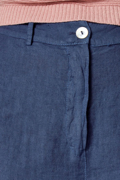 Gekleurde blauwe linnen broek van COPINES D'ANVERS, met parelmoeren knoopsluiting, onder een roze trui.