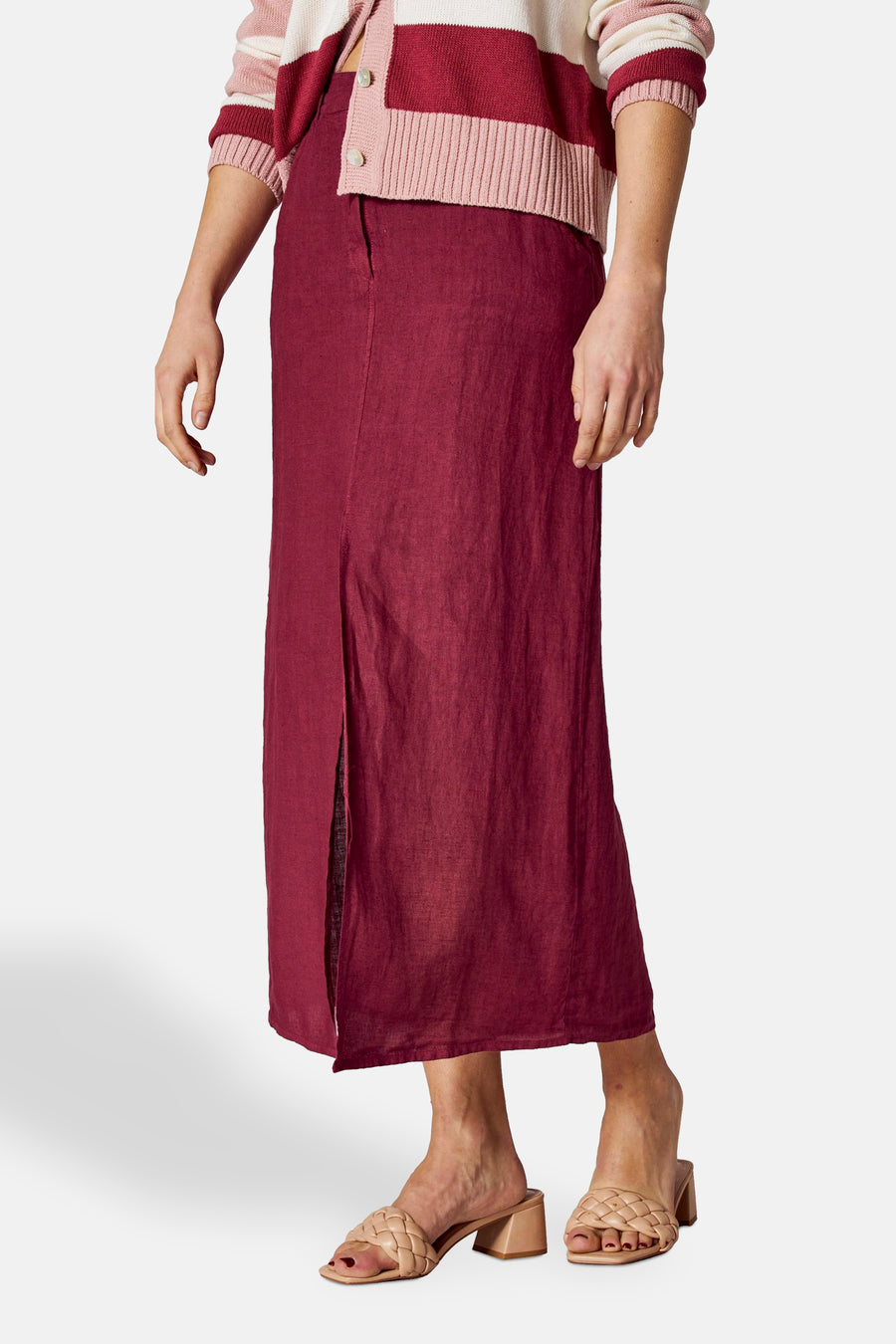 Lange bordeaux linnen rok van COPINES D'ANVERS met split, gedragen met een gestreepte roze en witte cardigan.