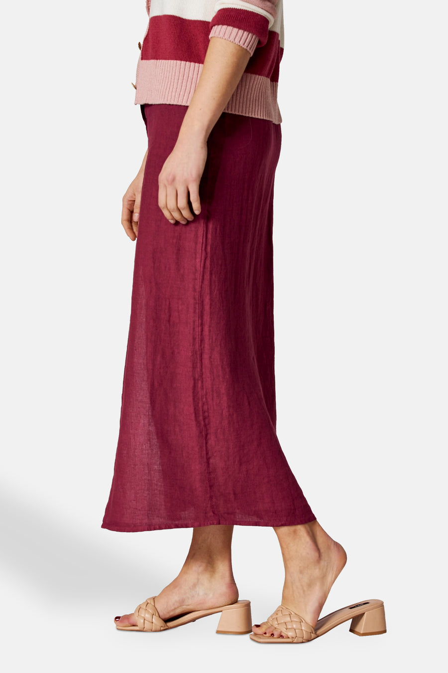 Bordeaux lange rok van COPINES D'ANVERS, rechte pasvorm, gedragen met een gestreepte cardigan en beige muiltjes met hak.