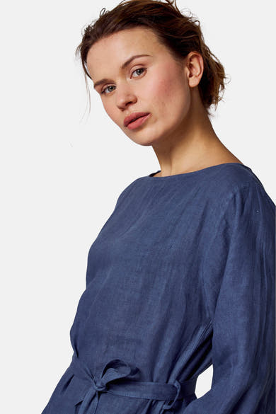 Blauwe linnen jurk van COPINES D'ANVERS, met een strikceintuur in de taille.