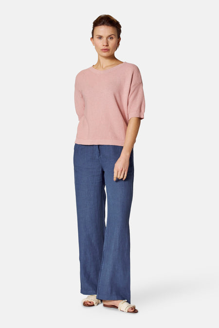 Ronde hals trui lichtroze van COPINES D'ANVERS, met horizontale ribbels, gedragen met een blauwe katoenen broek.