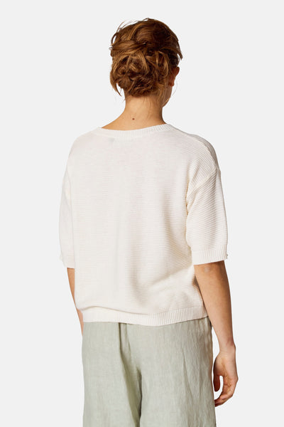Ronde mouw van COPINES D'ANVERS, met een geborduurde textuur, gedragen met een saffraangroen broek.