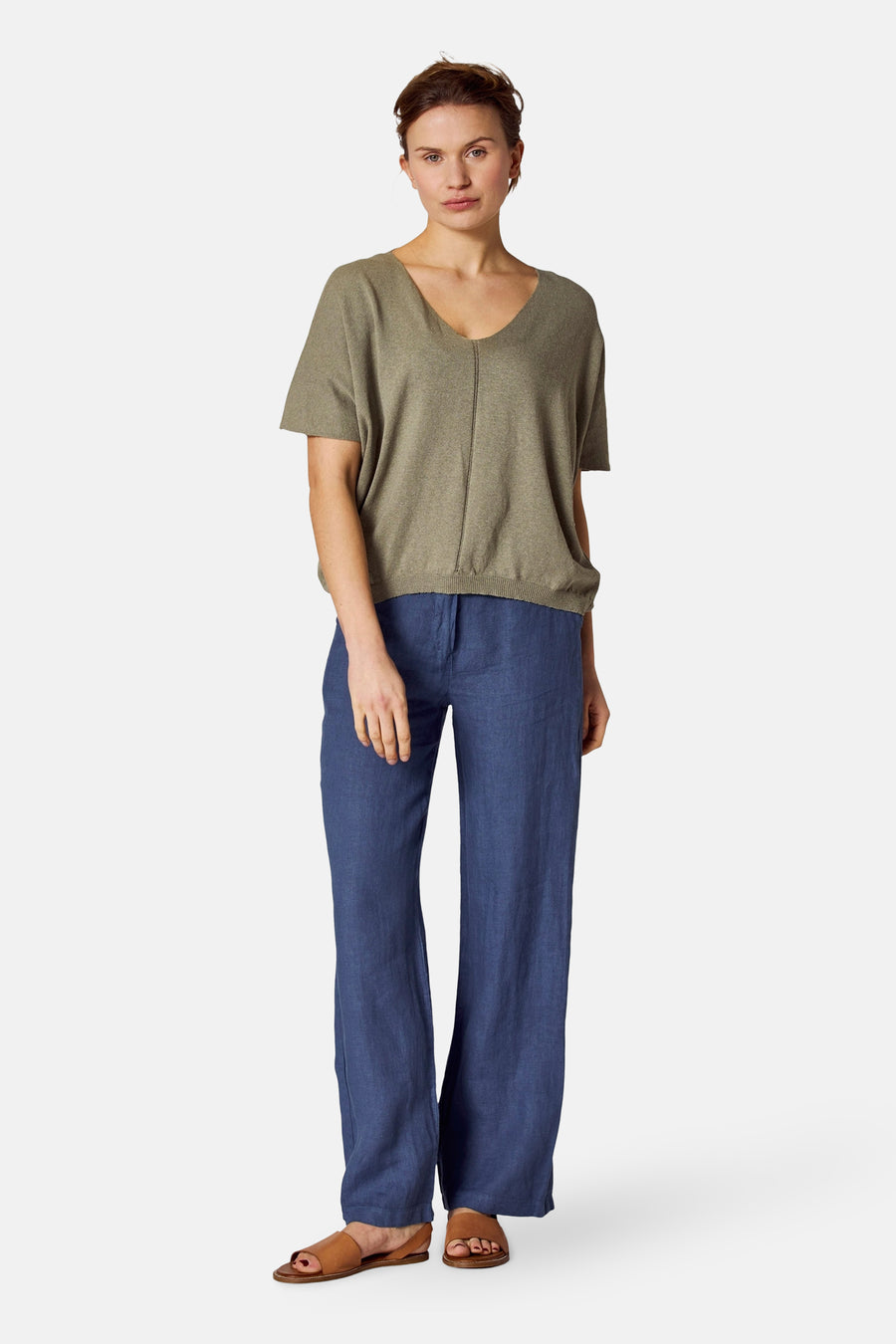 Groen gebreid topje van COPINES D'ANVERS, met een V-hals en korte mouwen, gedragen met een blauwe broek.