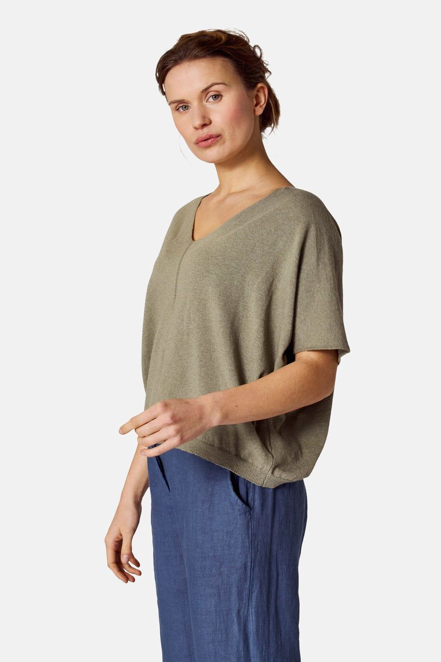 Top vert de COPINES D'ANVERS porté avec un pantalon bleu, en jersey à manches courtes, vue de côté.