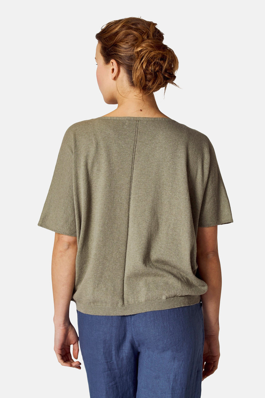 Groen COPINES D'ANVERS top, korte mouwen, verticale naaddetail op de rug, gedragen met een blauwe broek.