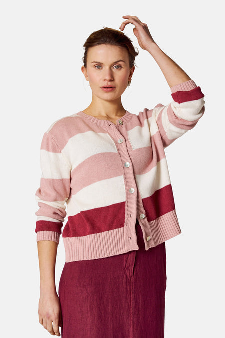 Roze gestreept gilet van COPINES D'ANVERS, gedragen met een bordeauxrode rok, van achteren gezien.