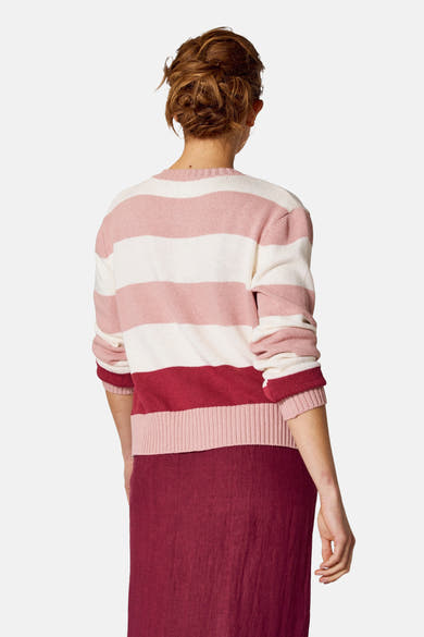 Gilet rose à rayures by COPINES D'ANVERS, porté avec une jupe bordeaux, vue de dos.
