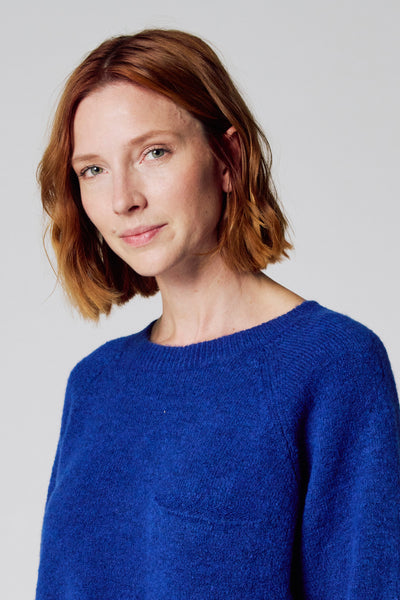 Ronde hals trui blauw van COPINES D'ANVERS, in textuur gebreid, gedragen door een vrouw met rood haar.