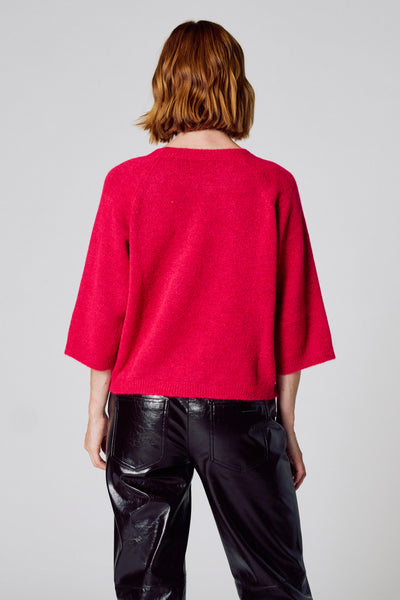 Pull à col rond rose de COPINES D'ANVERS, porté avec un pantalon en cuir noir, vue de dos.
