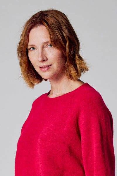 Roze trui met ronde hals van COPINES D'ANVERS, in pluizige stof, gedragen door een roodharige vrouw.