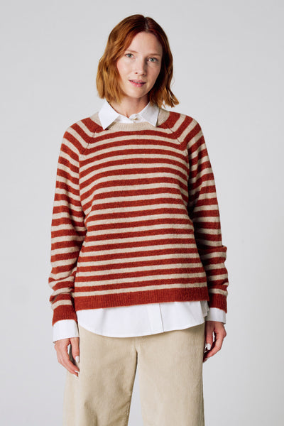 Bruine trui met ronde hals van COPINES D'ANVERS, met horizontale strepen, gedragen met een wit overhemd en een beige corduroy broek.