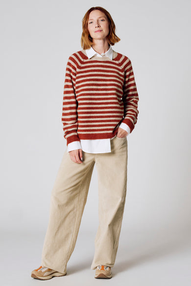 Bruine ronde trui van COPINES D'ANVERS, met horizontale strepen, gedragen met een wit overhemd en een corduroy broek.