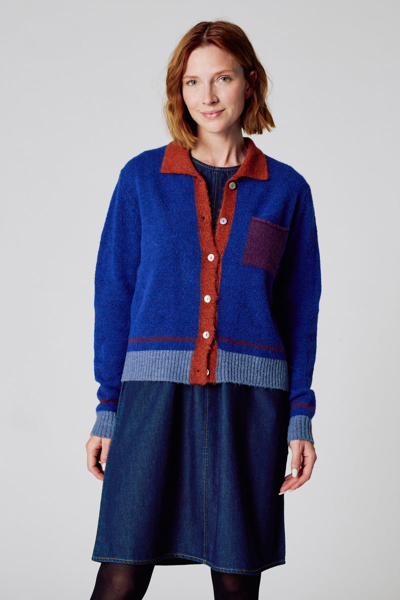 Blauwe gebreide cardigan van COPINES D'ANVERS, met contrasterende kraag en knoopsluiting.