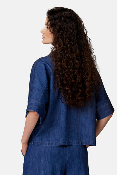 Blouse en jean bleu clair de COPINES D'ANVERS, coupe décontractée, manches larges retroussées, vue de dos.
