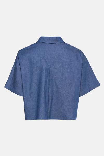 Kortemouwenblouse in denimblauw van NAF NAF, met een persvouw in het midden van de rug.