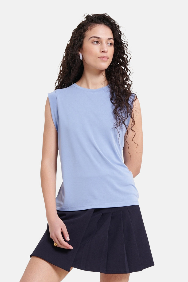 Blauw mouwloos topje van NAF NAF, gedragen met een ooraccessoire.