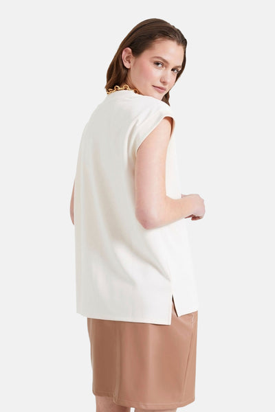 Ecru T-shirt met korte mouwen van NAF NAF, met een gouden kraag, gedragen met een bruine rok.