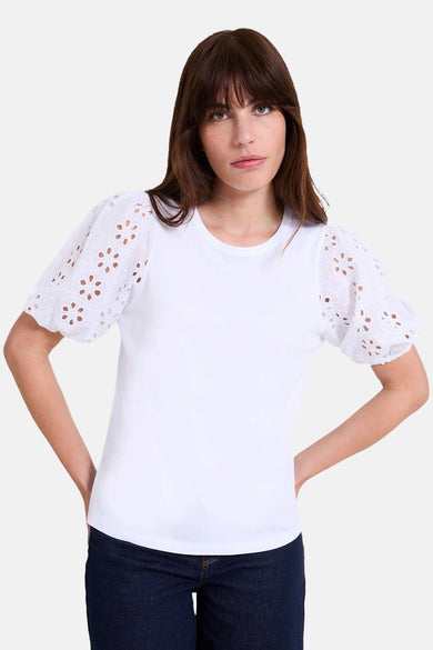 Blouse blanche à manches courtes de NAF NAF, avec détails ajourés aux manches bouffantes.