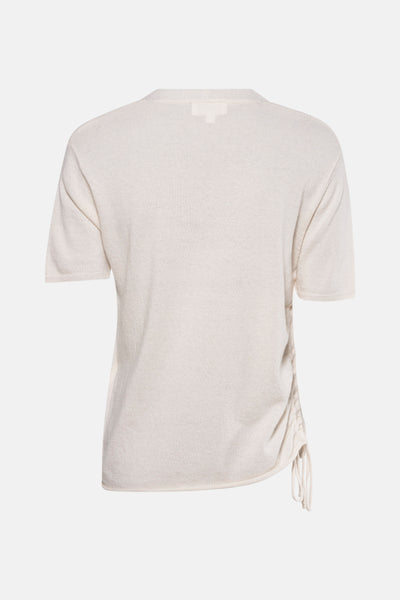 Pull à col en V écru de NAF NAF, avec cordon de serrage latéral et manches courtes.