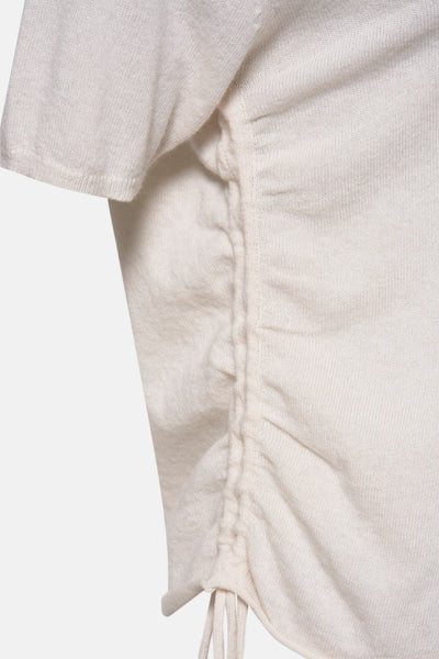 Pull à col en V écru de NAF NAF, détail froncé avec cordons de serrage, texture tricotée fine.