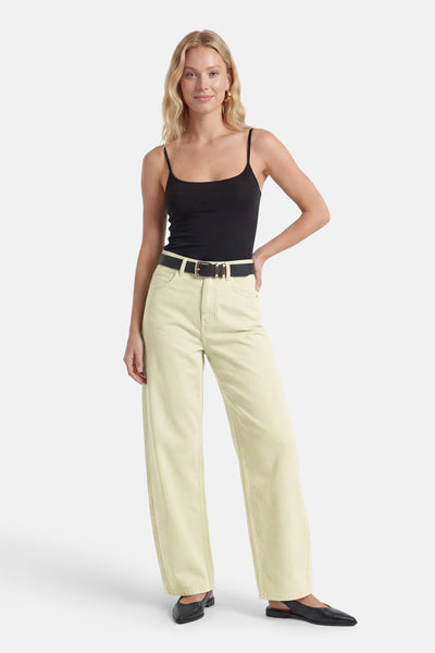 Light green high-waisted straight-leg jeans with five pockets, worn with black top and belt, full-length front view.