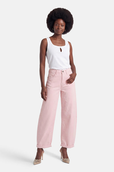 Rose corduroy wide-leg 5-pocket pants with cuffed hems, worn with white top and embellished heels, front view