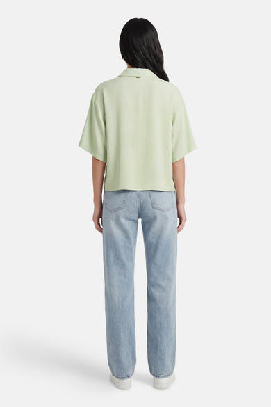Lichtgroen overhemd van AMELIE ET AMELIE, met wijde pasvorm en korte mouwen, gedragen met een lichtblauwe jeans.
